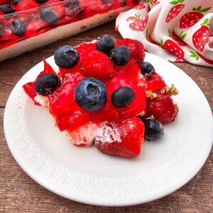 A close-up of a slice or portion of the Strawberry Blueberry Pretzel Salad, highlighting the layers.