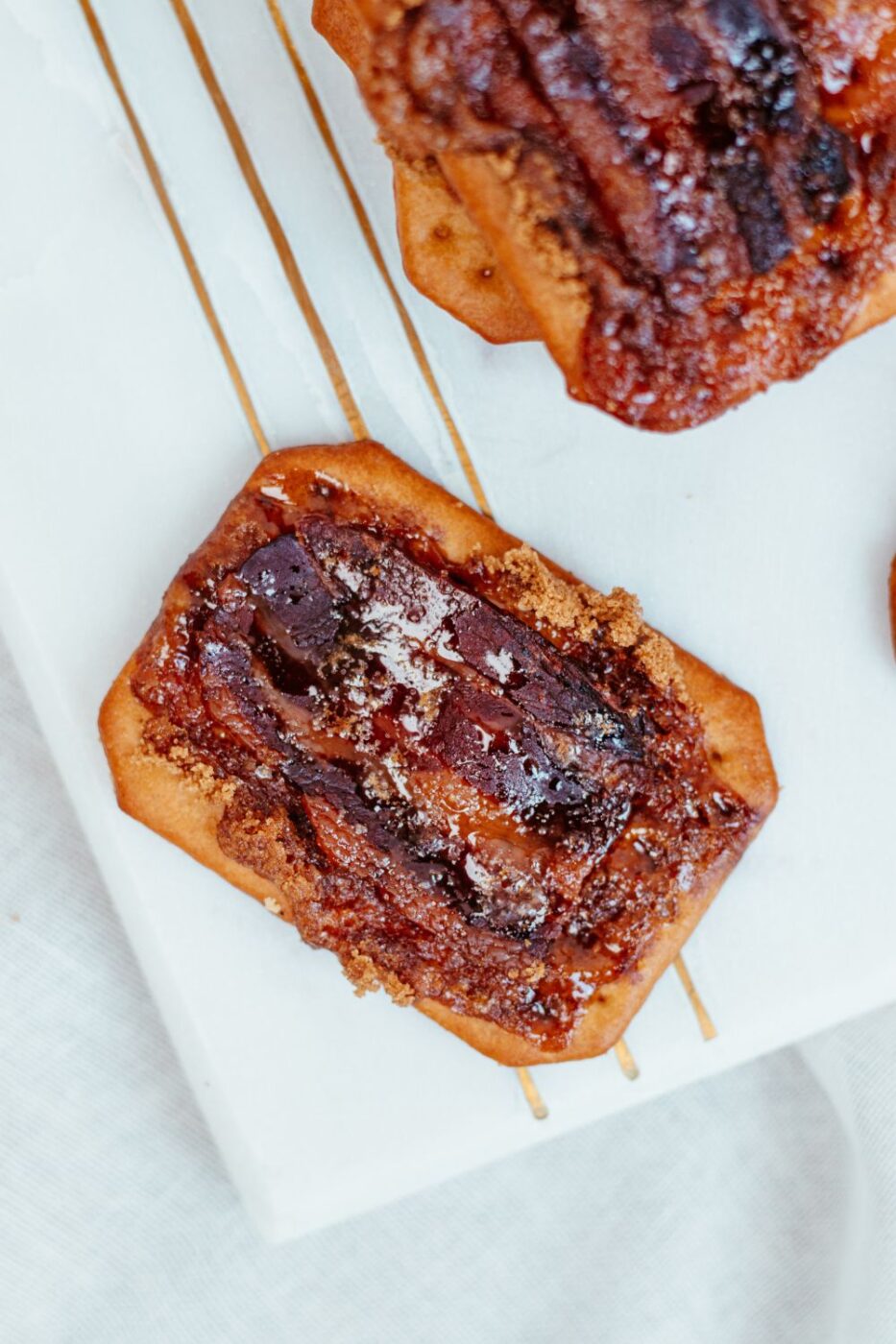Golden-brown, crispy bacon crackers on a baking sheet, fresh out of the oven.