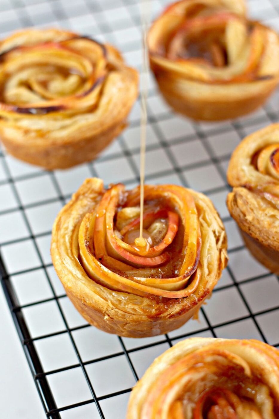 A close-up of a beautifully arranged apple rose tart with golden-brown pastry and thinly sliced apples.