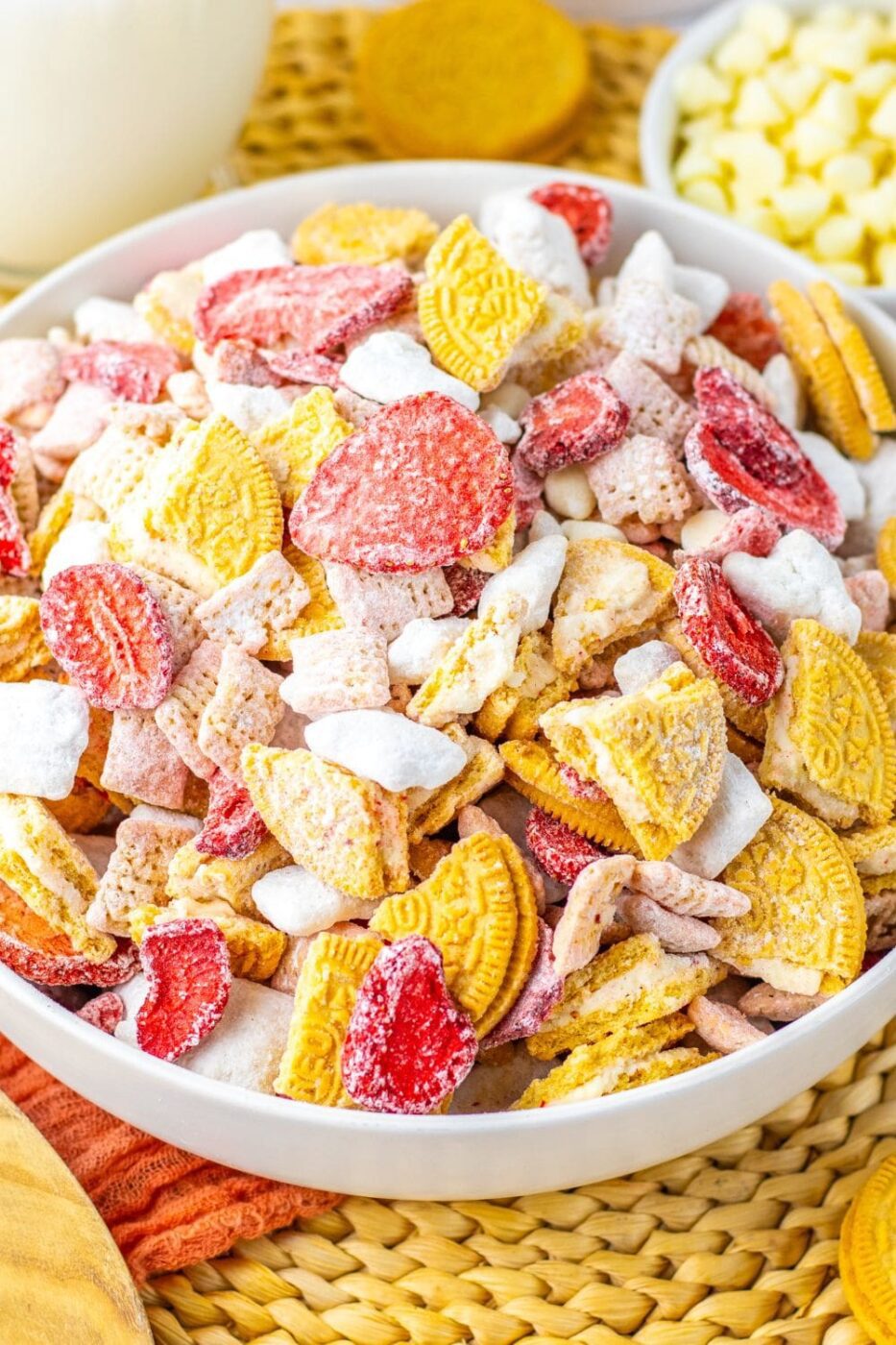 A bowl of pink strawberry shortcake puppy chow with white coating and sprinkles.