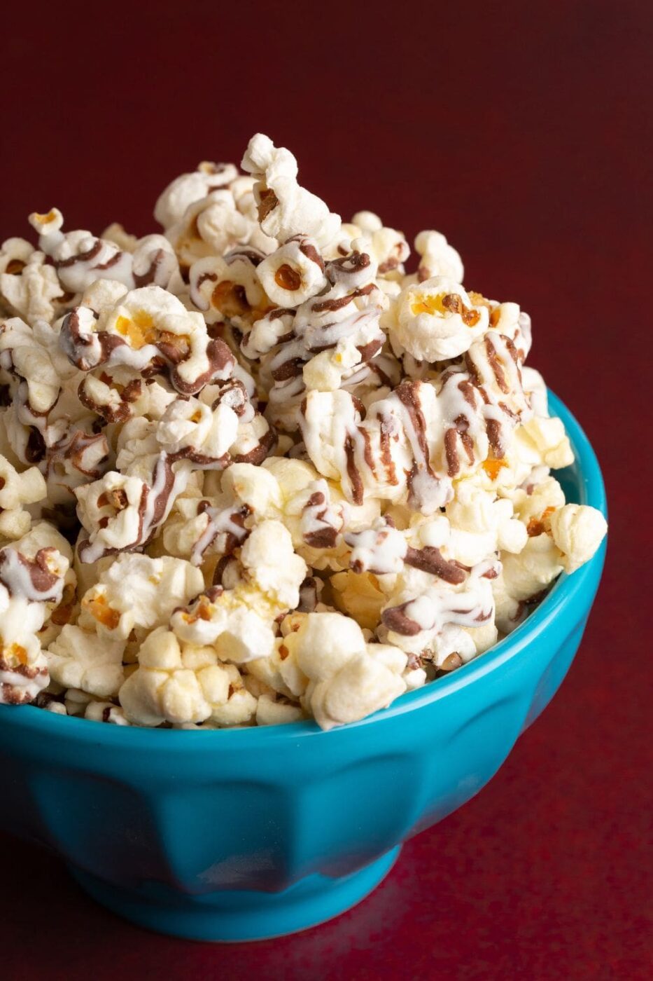 A large bowl filled with fluffy white chocolate popcorn, coated evenly.