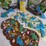 Chocolate bark broken into pieces, decorated with dinosaur cookies and fun toppings.