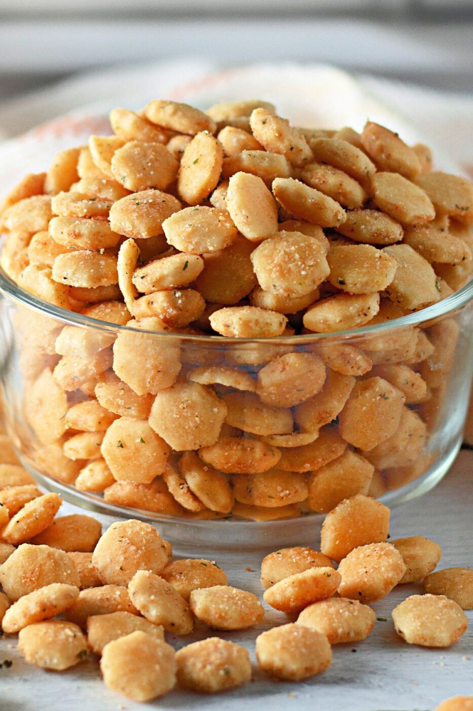 Seasoned oyster crackers in a bowl with ranch and herbs.