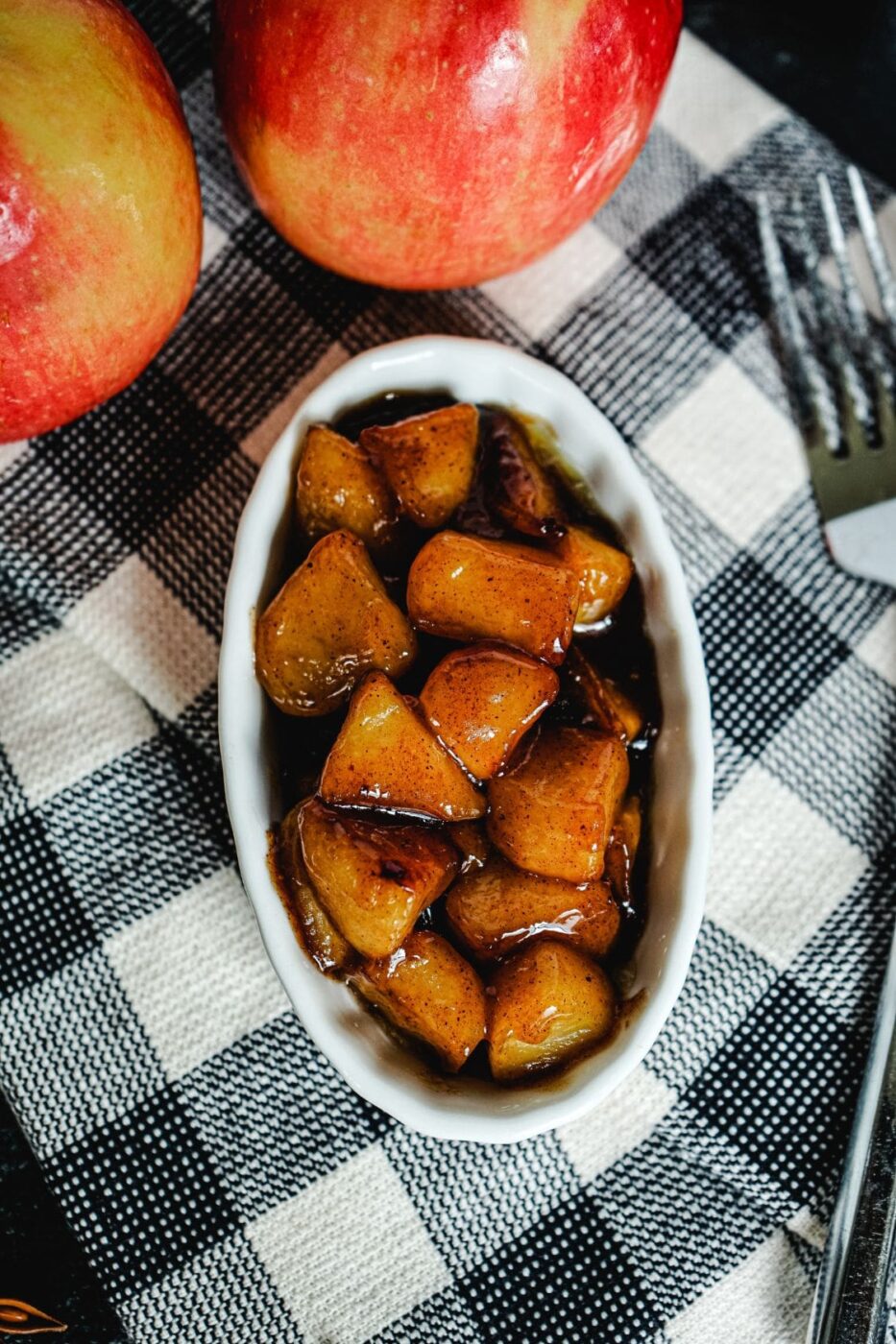 Saut&eacute;ed apple slices in a skillet with cinnamon and butter.