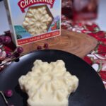 Challenge Butter Snowflake Shape on a black plate next to an unopened package of butter on a holiday table
