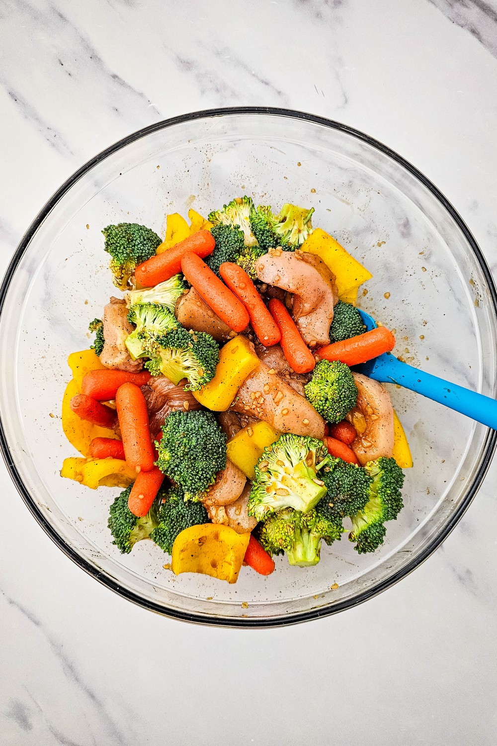 Chicken and vegetables tossed together in honey garlic sauce in a glass bowl