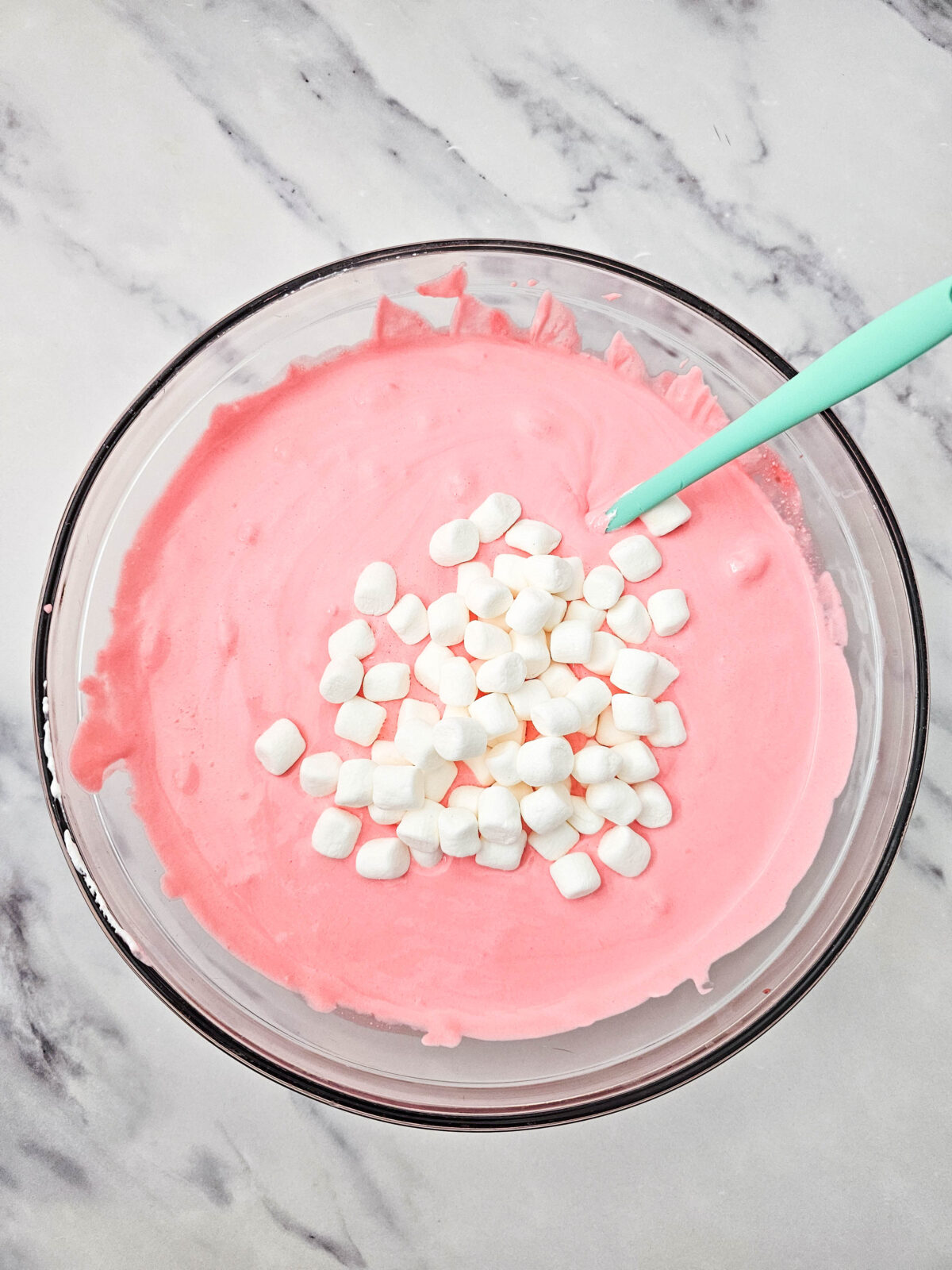 Mini marshmallows piled on top of the pink fluff mixture before folding