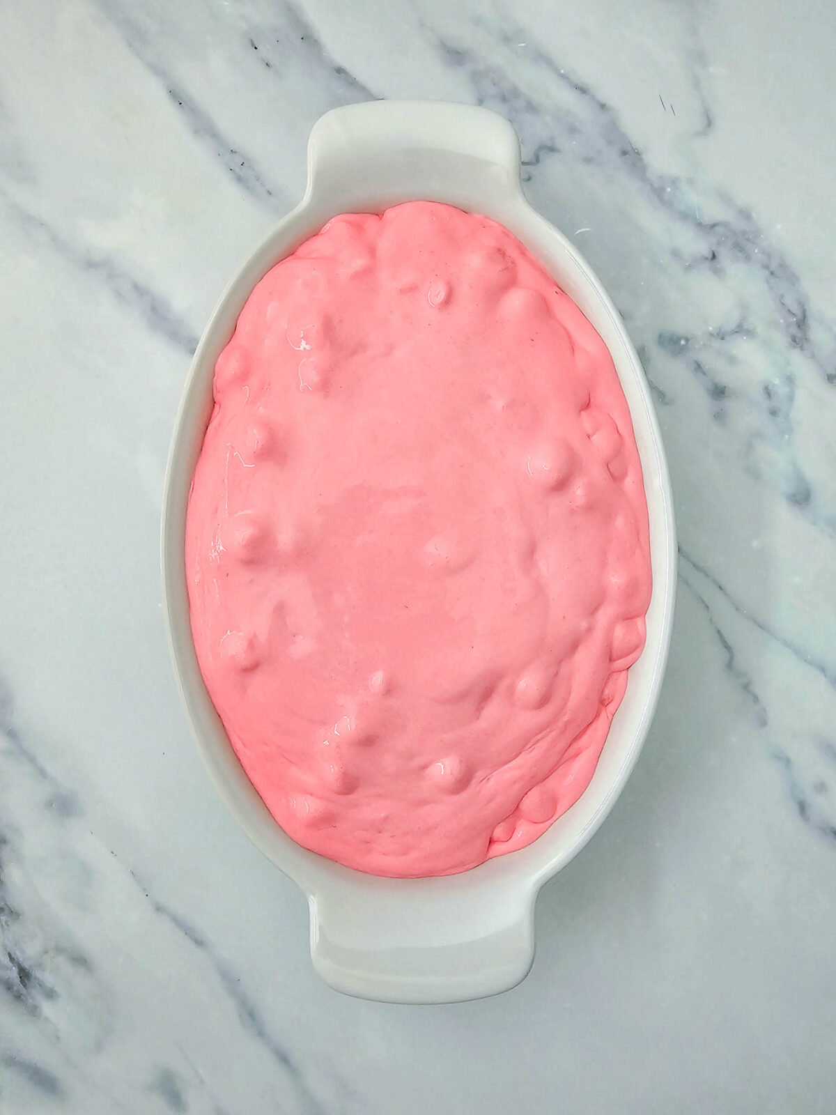 Finished pink fluff smoothed into a white oval serving dish, ready to chill