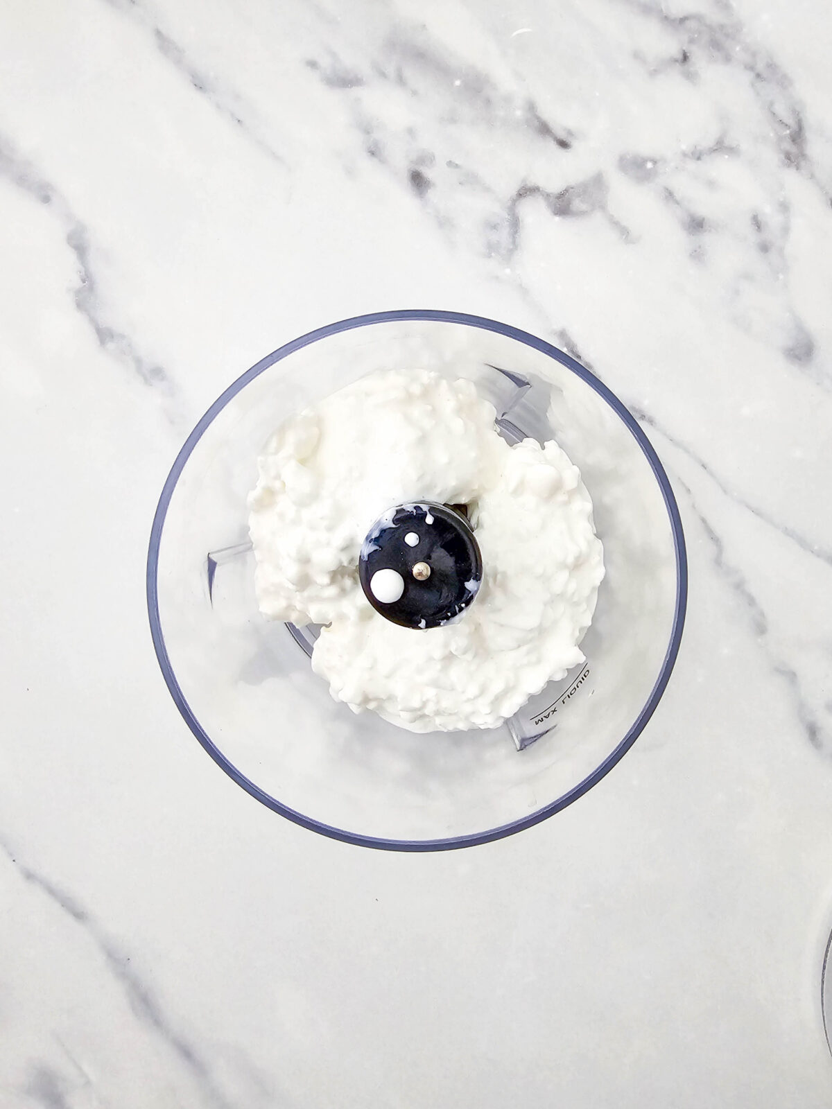 Cottage cheese curds added to a small food processor bowl
